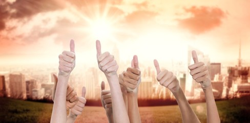 Composite image of thumbs raised and hands up 