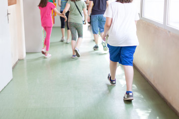 Fototapeta premium dzieci ze szkół podstawowych przechodzące przez szkolny korytarz