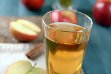 Glass of apple juice on wooden table, closeup