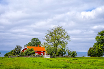 Ett r&ouml;tt hus vid sj&ouml;n