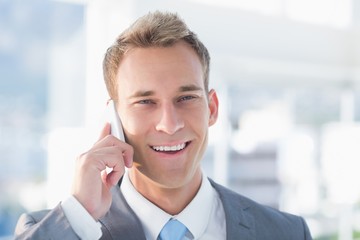 Smiling businessman calling on the phone 
