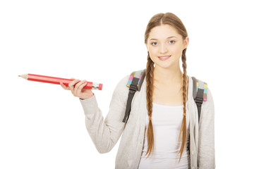 Schoolgirl pointing aside with pencil.