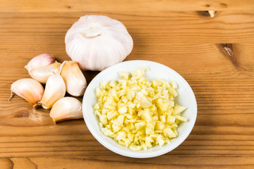 Chopped garlic in a plate with garlic bulb and cloves