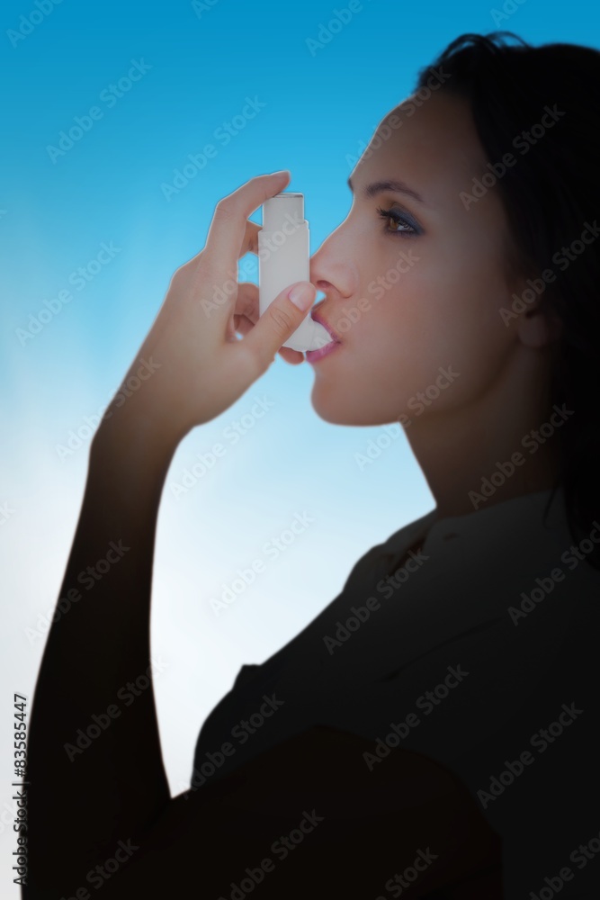 Poster Composite image of asthmatic brunette using her inhaler 