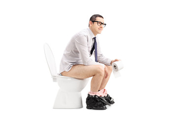 Young man sitting on a toilet