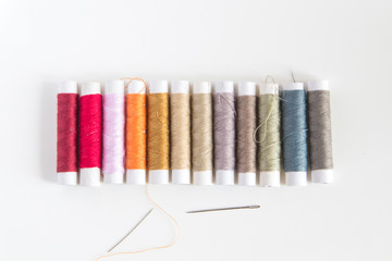 Colored sewing threads on a white table