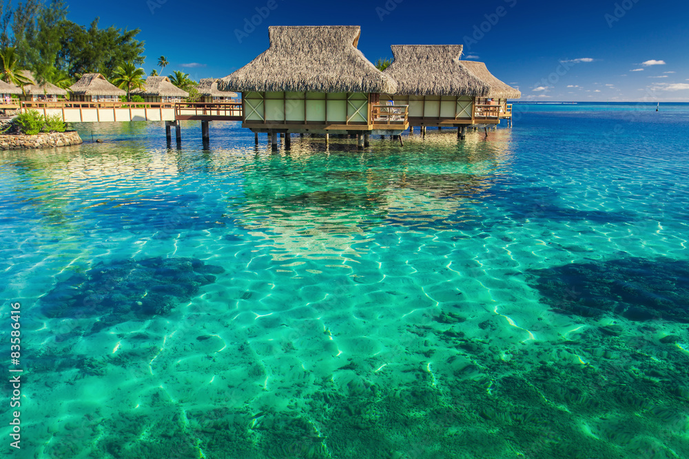 Wall mural Villas in the lagoon with steps into shallow water with coral