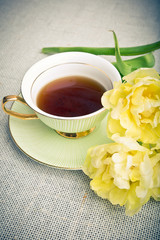 Cup of tea and yellow tulips