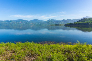 Fototapeta na wymiar View of reservoir blue sky and green grass