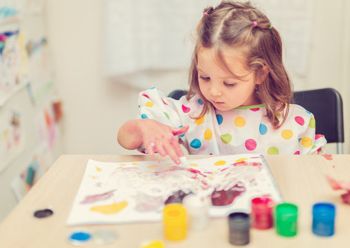 cute little girl finger painting