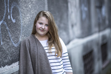 Portrait of cute teen girl standing on the street.