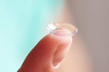 Womans finger with contact lens