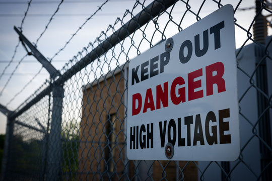 Danger Keep Out High Voltage Sign On Barbed Wire Fence