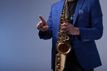 Fototapeta premium Music concept. musician with a saxophone icon clicks on the virt