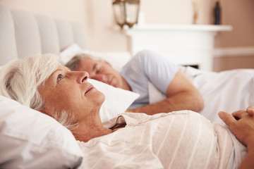 Fototapeta na wymiar Worried Senior Woman Lying Awake In Bed