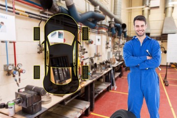 Smiling mechanic with arms crossed standing by tire