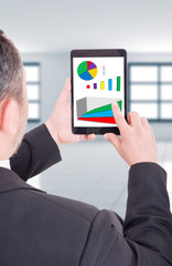Business man holding tablet with financial charts
