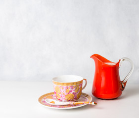 Fototapeta premium antique cup and saucer and milk in a glass jar orange