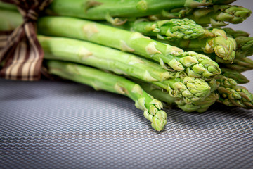  Asparagus bind with brown ribbon on blue grey background