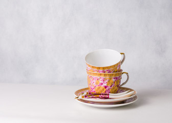 two vintage cups, sauceres and spoons on a white background