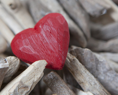 cœur en bois rouge sur fond de bois flotté 