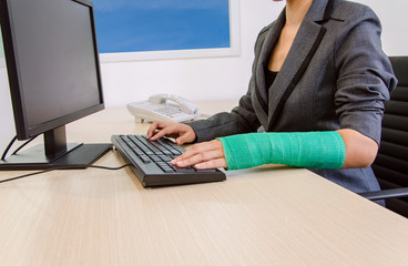 Injured businesswoman hand  typing on computer keyboard.