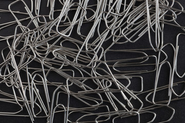 metal paper clips on a black background