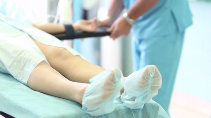 Surgical team preparing patient for the cosmetic surgery