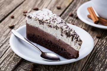 Chocolate dessert with coffee cup and coffee beans on wooden bac