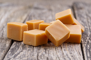 Tasty toffees on wooden background.