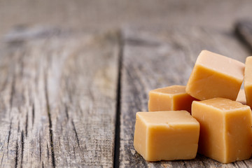 Tasty toffees on wooden background.