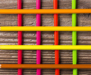 Coloured pencils on wooden background
