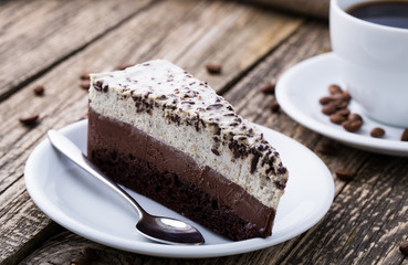 Chocolate dessert with coffee cup and coffee beans on wooden bac