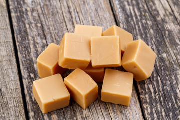 Tasty toffees on wooden background.