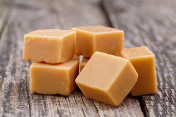 Tasty toffees on wooden background.