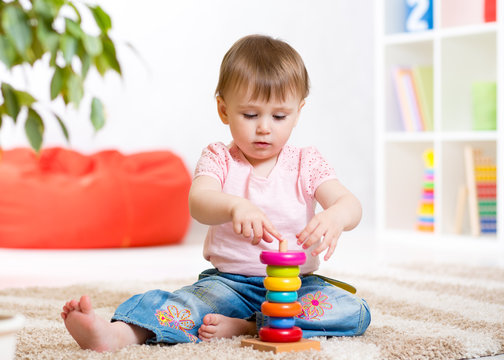 Child girl playing with toy at home