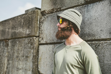 Thoughtful Man with Unshaven Beard Leaning on Wall