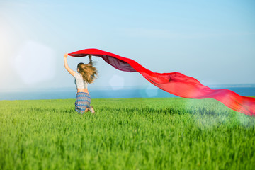 Young happy woman in wheat field with fabric. Summer lifestyle