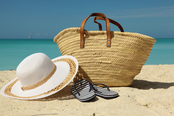 white sun hat and bag on the beach