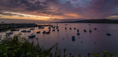 Dawn breaking over a harbour with small boats and yachts