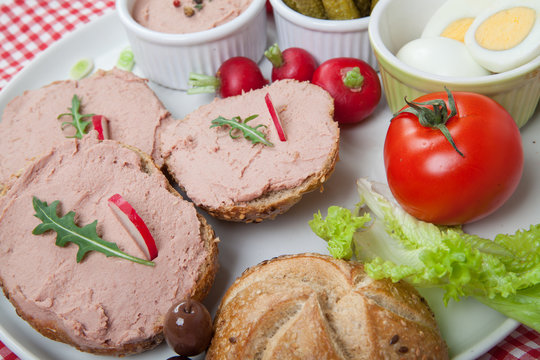 plate with slices of bread with home made pate, with vegetables