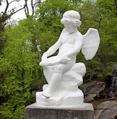 statue of white marble infant angel in the park - 83609048