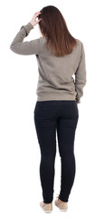 back view of standing young beautiful  woman.  Girl scratching h