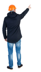 Back view of  pointing young men in parka and helmet.