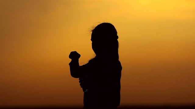young girl blowing bubbles at sunset. 
