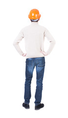 Backview of an engineer in construction helmet stands