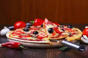 Baked hot pizza with one slice on lifter