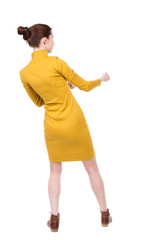 Fototapeta premium back view of standing woman pulling a rope from the top or cling