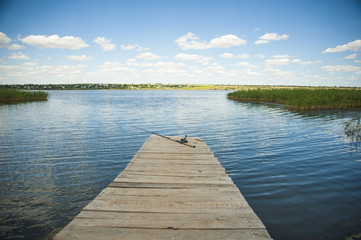 Fototapeta na wymiar Fishing rod on old wooden pier