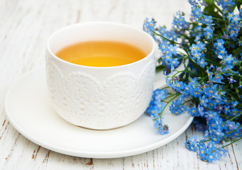 Cup of teand forget me not flowers